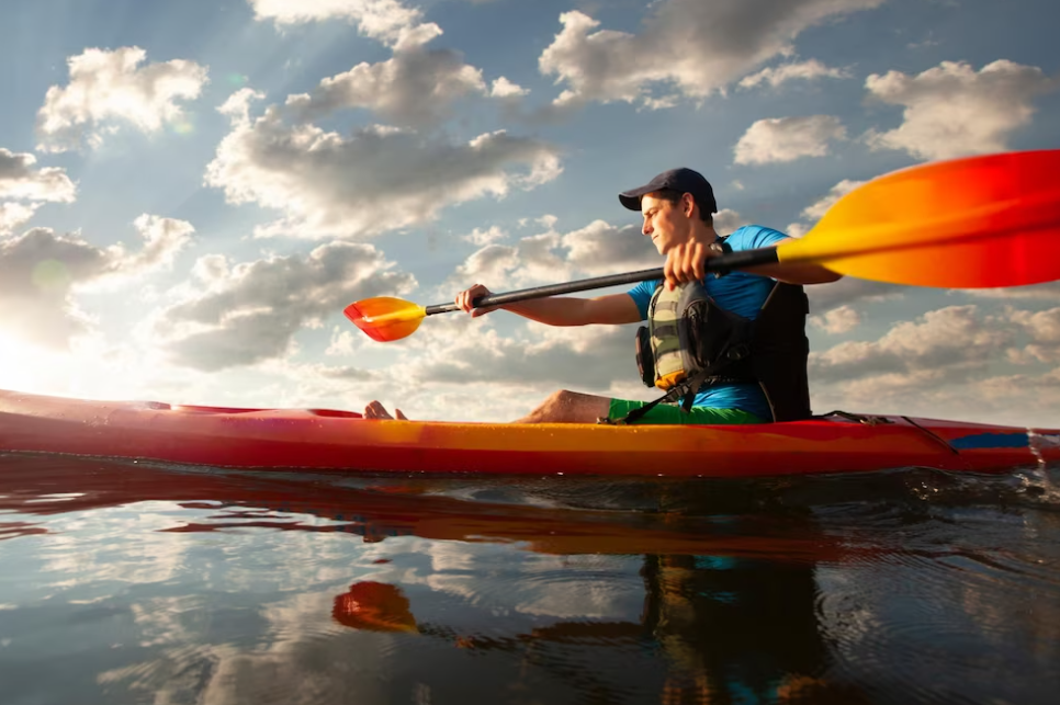 man with a canoe paddle on the river and cloudy sky above