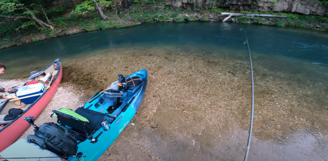 Two canoes on the water with a fishing rod