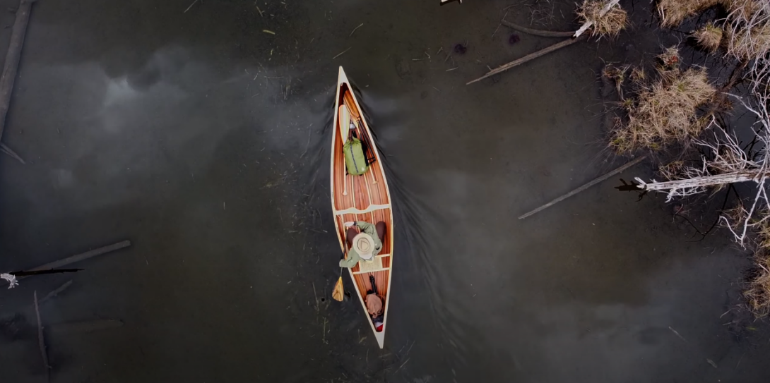 Aerial view of a man paddling a canoe on the lake